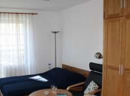 Doppelbett, Sessel und Schrankwand